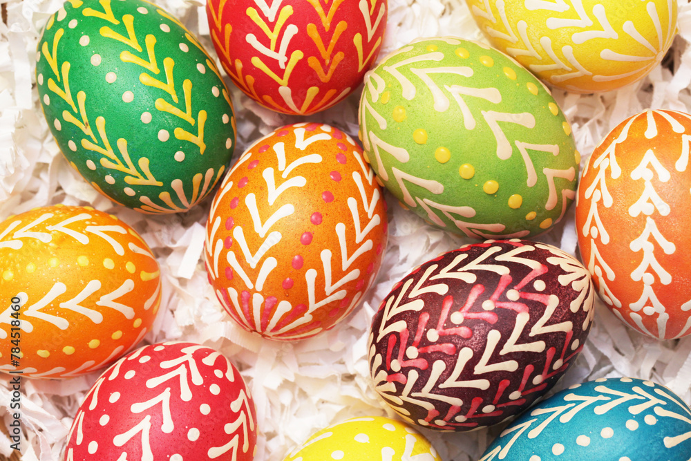 Handmade easter eggs. Vibrant color painted chicken eggs for celebrating easter holiday. Wicker basket filled with decorated eggs background. Hot wax technique of decorating. DIY project. Handmade easter eggs. Vibrant color painted chicken eggs for celebrating easter holiday. Wicker basket filled with decorated eggs background. Hot wax technique of decorating. DIY project.