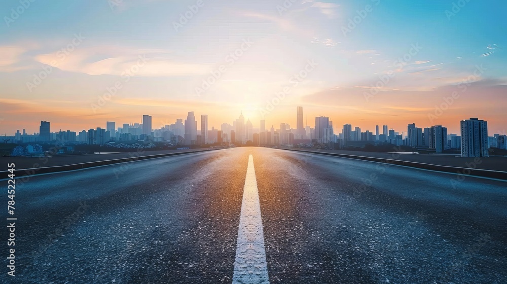 An empty asphalt road extends into a modern city skyline at sunset, offering a high-angle view that captures the urban scenery in a tranquil moment - obrazy, fototapety, plakaty 