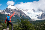 Hombre turista alzando su baston de trekking y disfrutando su recorrido por el sendero a la laguna torre, en el Chalten, Patagonia Argentina	