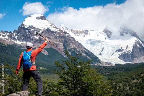 Hombre turista alzando su baston de trekking y disfrutando su recorrido por el sendero a la laguna torre, en el Chalten, Patagonia Argentina 