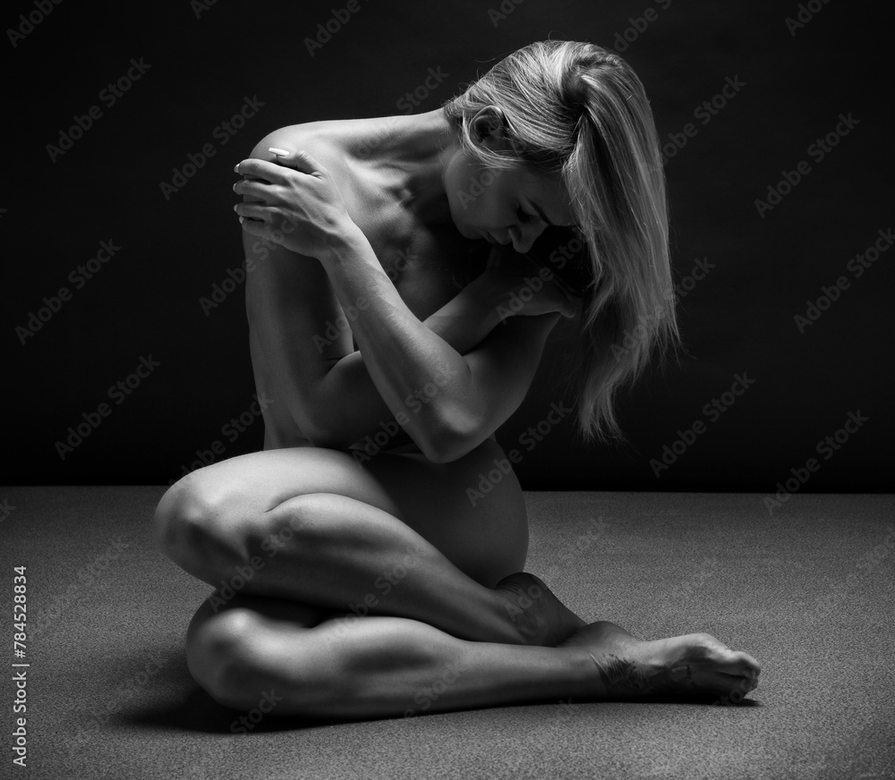 Fototapeta premium Art black and white photo of naked beautiful woman. Beauty nude yoga girl posing on black background. 