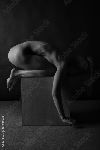 Art black and white photo of naked beautiful woman. Beauty nude yoga girl posing on black background. 
