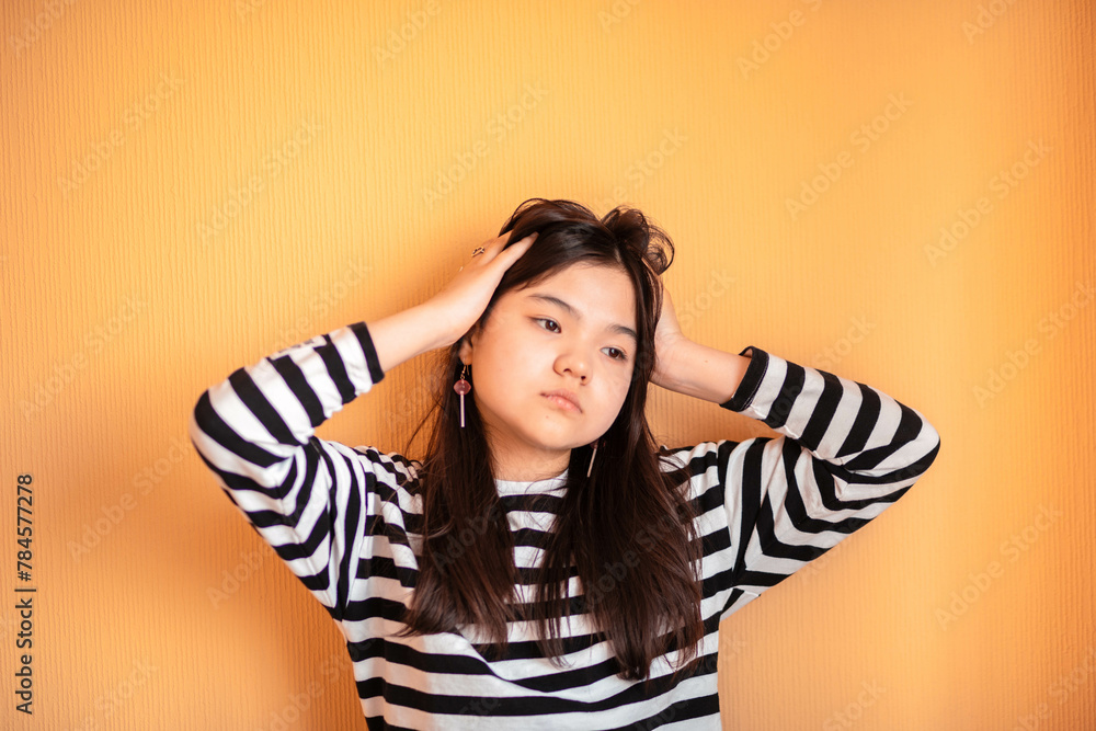 Contemplative Youth : A teenager lost in thought, her expression serene against the vibrant orange backdrop Contemplative Youth : A teenager lost in thought, her expression serene against the vibrant orange backdrop