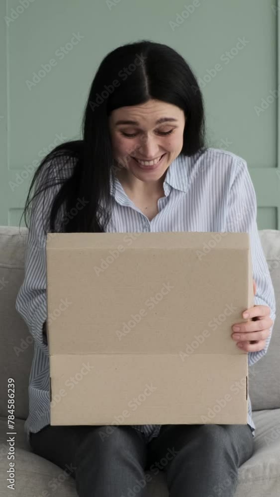 Happy Caucasian woman delighted by parcel or purchase from online shop at home. Satisfied customer, online shopping concept. Vertical video. Happy Caucasian woman delighted by parcel or purchase from online shop at home. Satisfied customer, online shopping concept. Vertical video.
