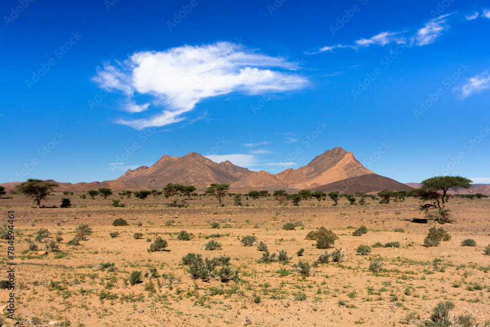 mountains appear behind the sahara desert on the way to the moroccan atlas