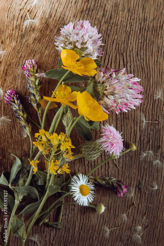 Wild flowers on old grunge wooden background (Aster amellus, Buttercup, Lucerne, Cirsium, Trifolium)