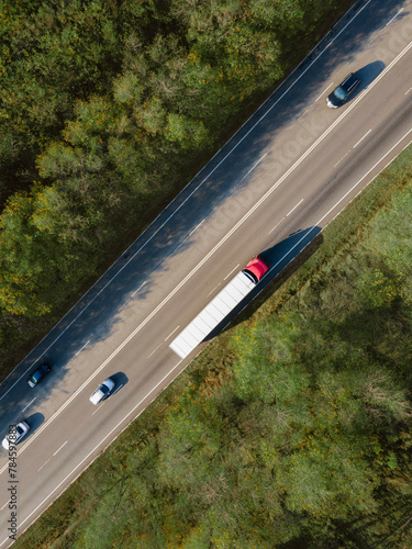 Asphalt highway or motorway road in countryside with car and truck traffic Cargo Semi Trailer Moving. Aerial Top View