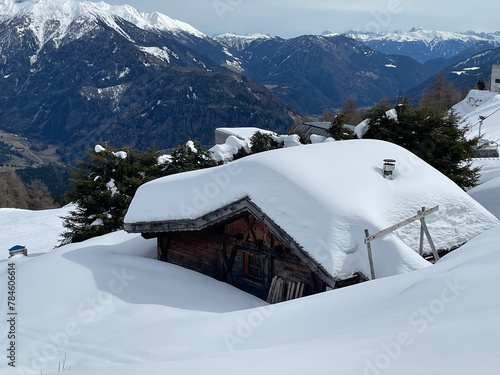 Fototapeta Naklejka Na Ścianę i Meble -  a snow covered wooden hut in the mountains in winter season