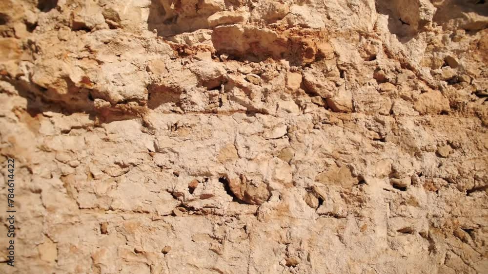 Panoramic shot of a street wall decorated with clay rocks. A clay stone decorated wall. Panoramic shot of a street wall decorated with clay rocks. A clay stone decorated wall.
