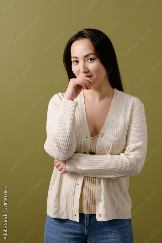 Portrait of asian woman in cardigan looking at camera isolated on green Portrait of asian woman in cardigan looking at camera isolated on green