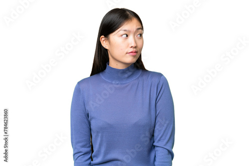 Young Asian woman over isolated chroma key background making doubts gesture looking side