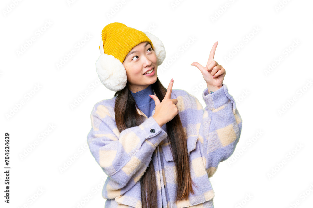 Young Asian woman wearing winter muffs over isolated chroma key background pointing with the index finger a great idea Young Asian woman wearing winter muffs over isolated chroma key background pointing with the index finger a great idea
