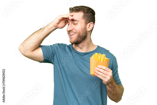 Young handsome blonde man holding fried chips over isolated chroma key background smiling a lot