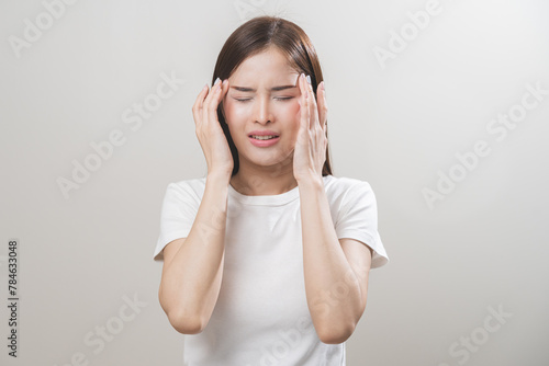 Dizzy asian young woman, girl headache or migraine pain suffering from vertigo while sitting on couch in living room at home, holding head with hand, health problem of brain or inner ear not balance.