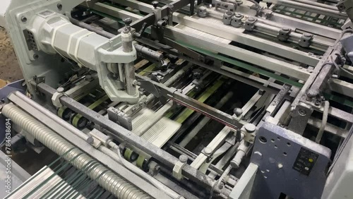 Book, magazine, production line into press plant house. Automatic assembly line, selective focus and copy space