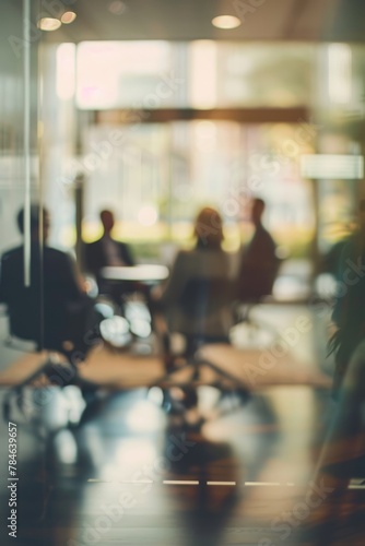 business professionals are captured in a blurred office setting, seated around chairs engaged in a meeting 