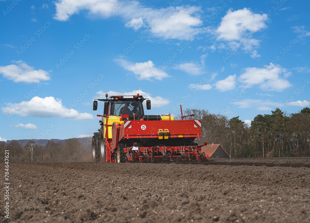 Fototapeta premium Kartoffeln legen mit moderner Landtechnik im Frühling - Heckansicht.