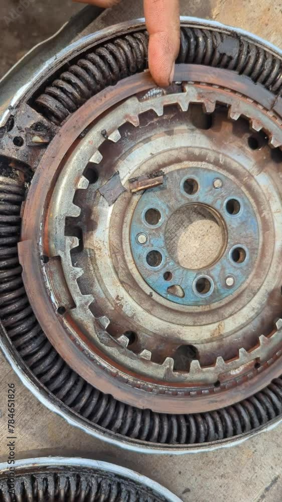 The flywheel opened up and heavily worn, with scattered parts inside, from an old diesel car. Auto service and car repair. Educational for auto mechanics. The flywheel opened up and heavily worn, with scattered parts inside, from an old diesel car. Auto service and car repair. Educational for auto mechanics.