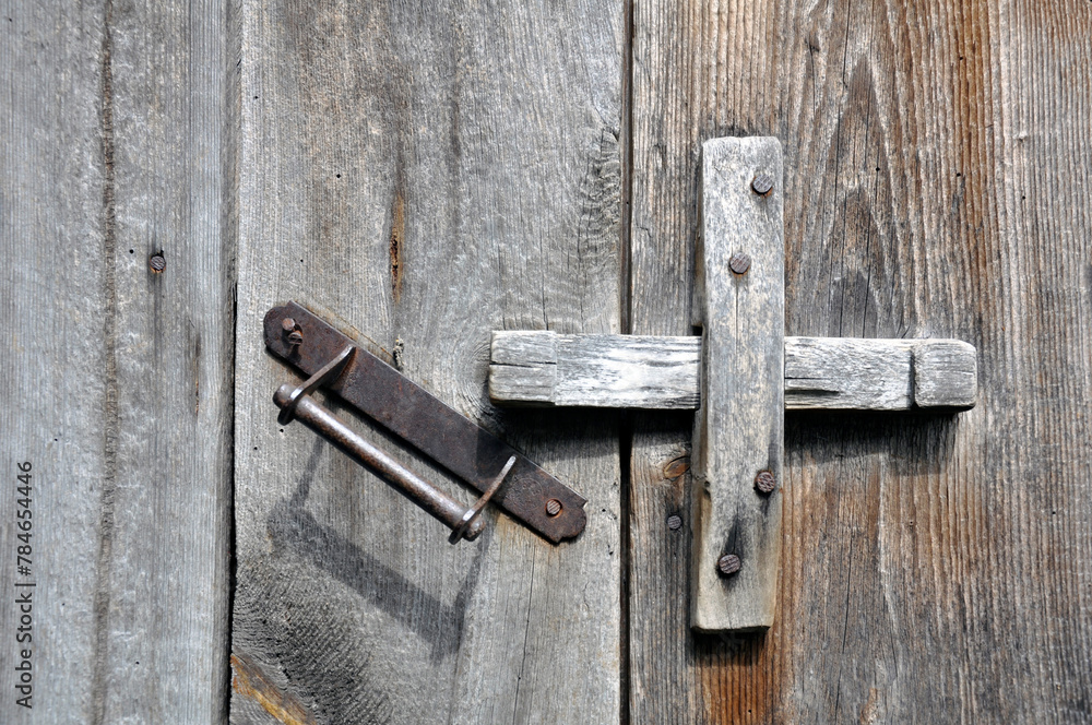 Old lock on the door. Locking device of an old farmhouse. Background. Old lock on the door. Locking device of an old farmhouse. Background.