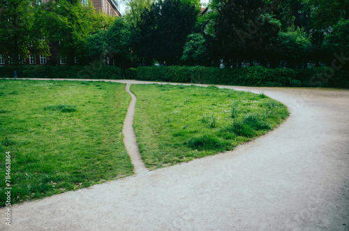 Desire Path in Park - A worn grass desire path splits off from a main gravel walkway in a verdant urban park, offering a shortcut through the greenery at Heidelberger Platz Berlin