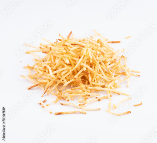 portion of shoestring potatoes scattered in white background top view