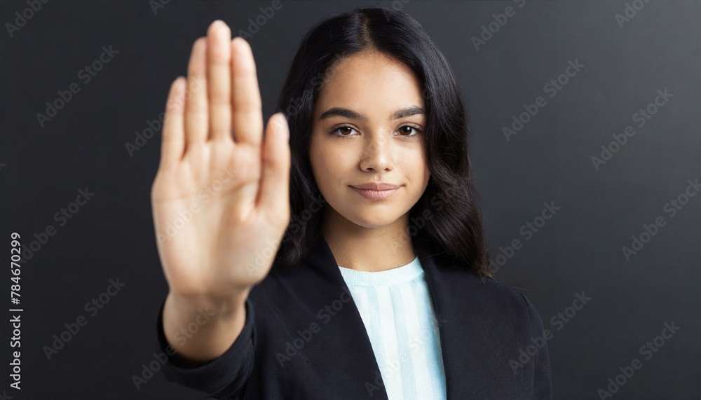 Close up of woman showing stop gesture with hand raising up on black background, young female protesting against domestic violence and abuse, bullying, saying no to gender discrimination Close up of woman showing stop gesture with hand raising up on black background, young female protesting against domestic violence and abuse, bullying, saying no to gender discrimination