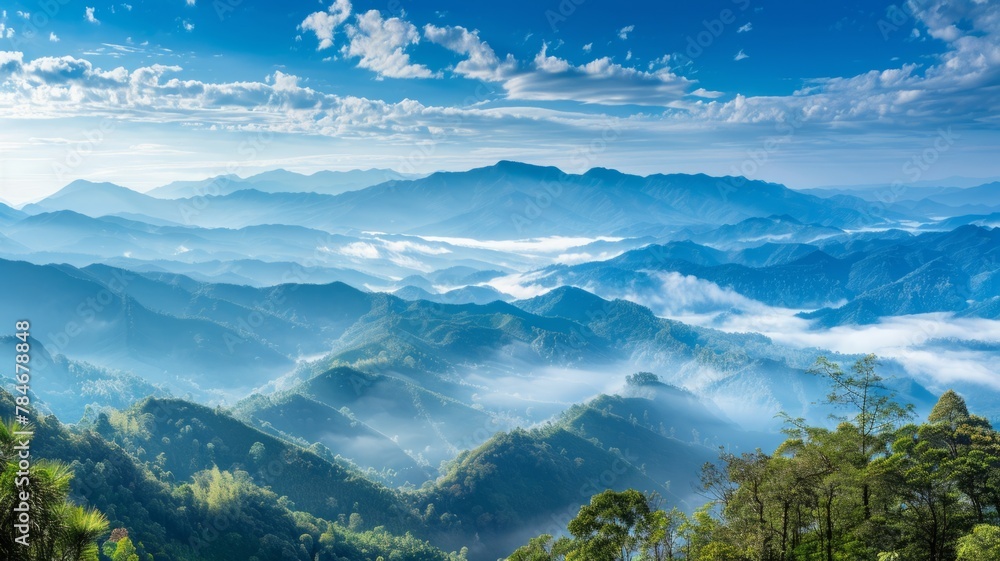 Breathtaking mountain panorama with clouds - An awe-inspiring panoramic view of cloud-covered mountain peaks bathed in sunlight highlights the beauty of nature