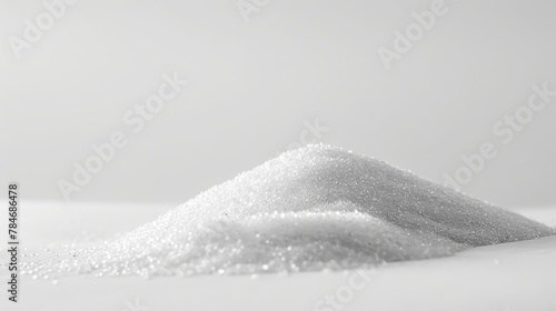 Fine white sand sits in a pile on a plain white surface.
