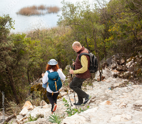 senior couple hiking outdoor, man and woman norwegian walking with sticks