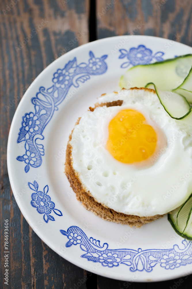A fried egg on a piece of bread with a cucumber A fried egg on a piece of bread with a cucumber