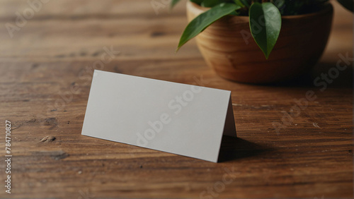 Clean minimal business card mockup on wooden plate with small leaves