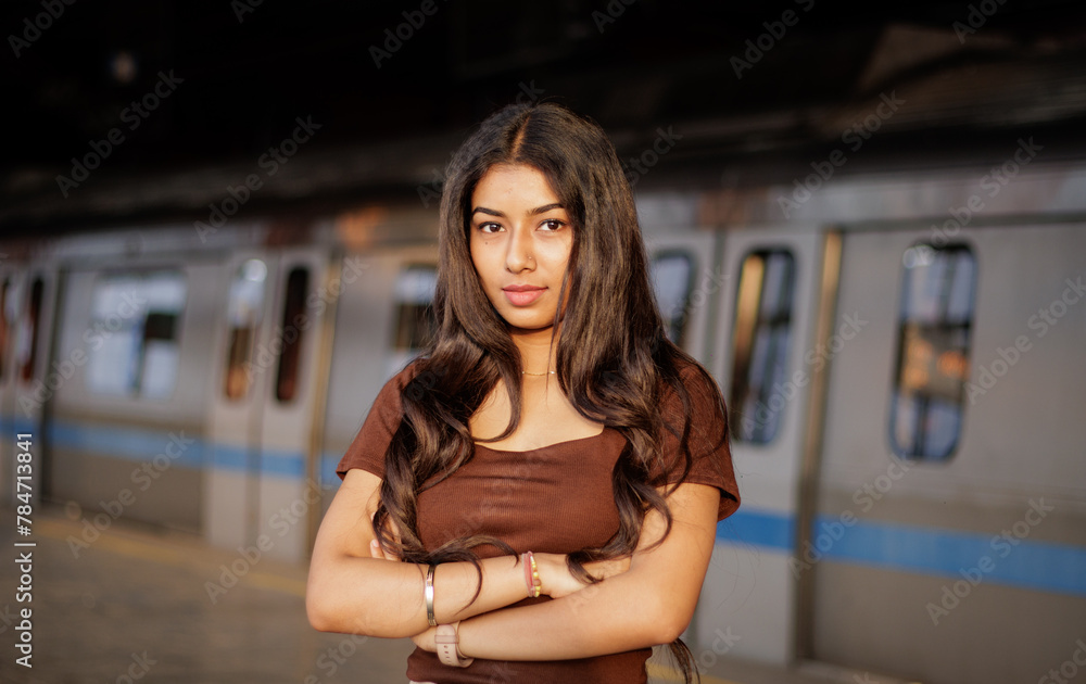 Young woman standing on a metro station platform and waiting for a metro train. People travel in public transport concept. Young woman standing on a metro station platform and waiting for a metro train. People travel in public transport concept.