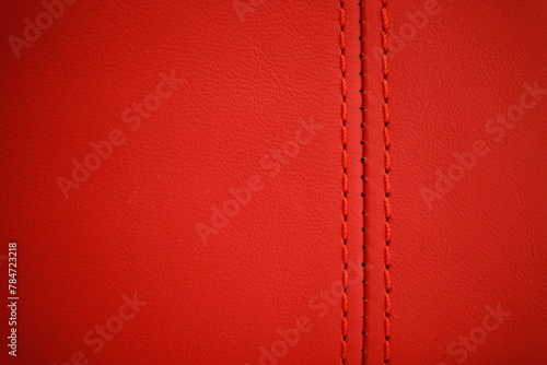 Red thread close-up on a blurred background of red leather car seat