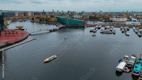 Aerial drone view NEMO museum in Amsterdam autumn cityscape narrow old houses  canals  boats bird s eye view