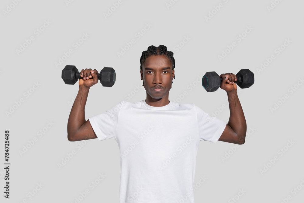 Athletic man lifting dumbbells on white background Athletic man lifting dumbbells on white background