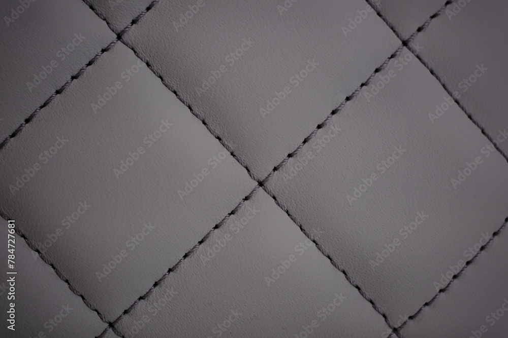 Dark gray contrast thread on natural gray leather car seat close-up - obrazy, fototapety, plakaty 