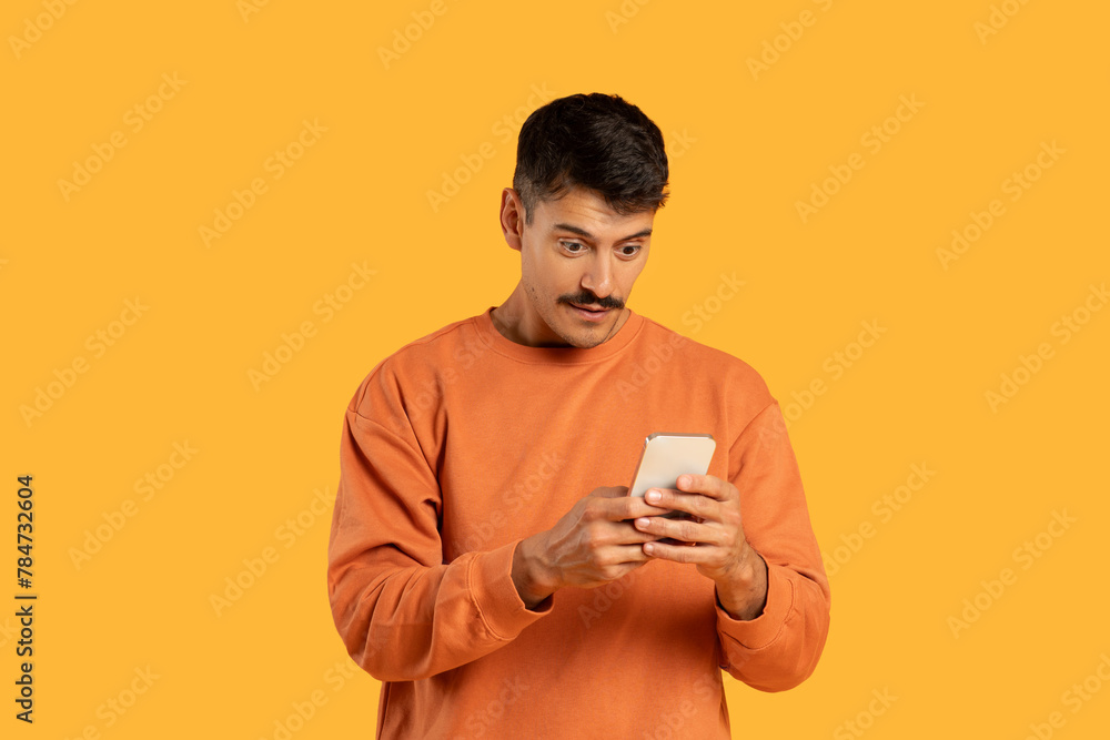 Man looking at phone with curious face Man looking at phone with curious face