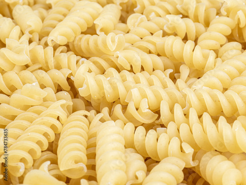 A pile of raw italian fusilli spiral pasta. Texture background.
