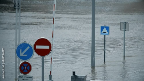 Flooded road with road signs, River Seine in Paris, France. Text in French: except lafarge vehicles photo