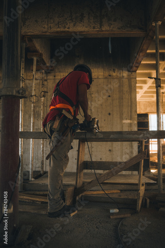 Trabalhador cortando madeira em obra photo