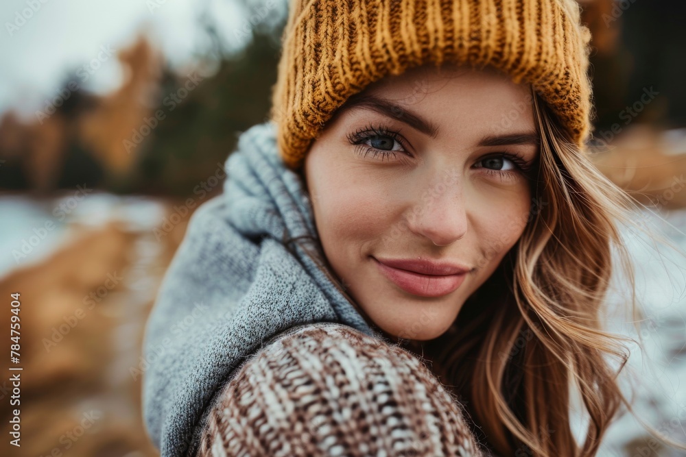 Attractive young woman with beanie smiling in an autumn setting by the lake Attractive young woman with beanie smiling in an autumn setting by the lake