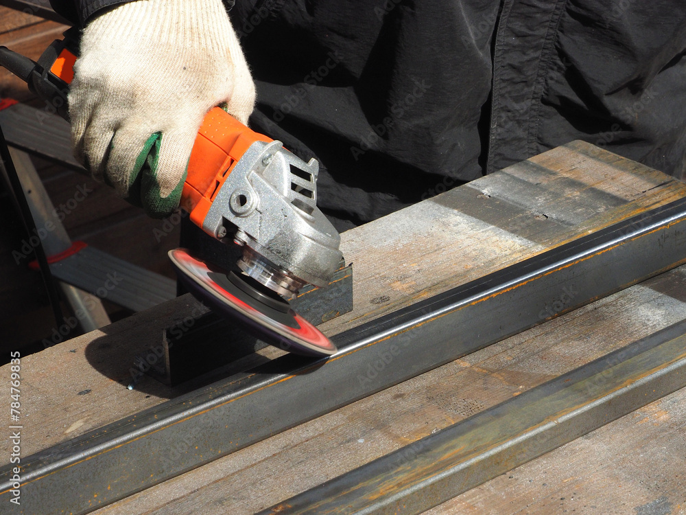 A worker processes metal with an angle grinder on a construction site.
The concept of locksmith work, processing of metal products.