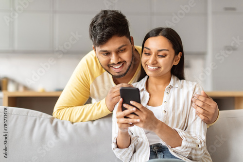 Young couple looking at smartphone together at home