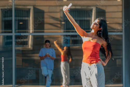 young woman taking a selfie with mobile phone on the street