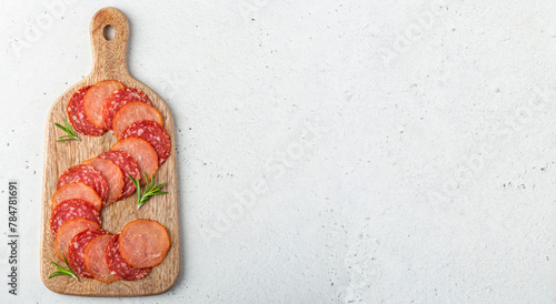 Overhead shot og a wooden serving board with two types of raw dries sausage