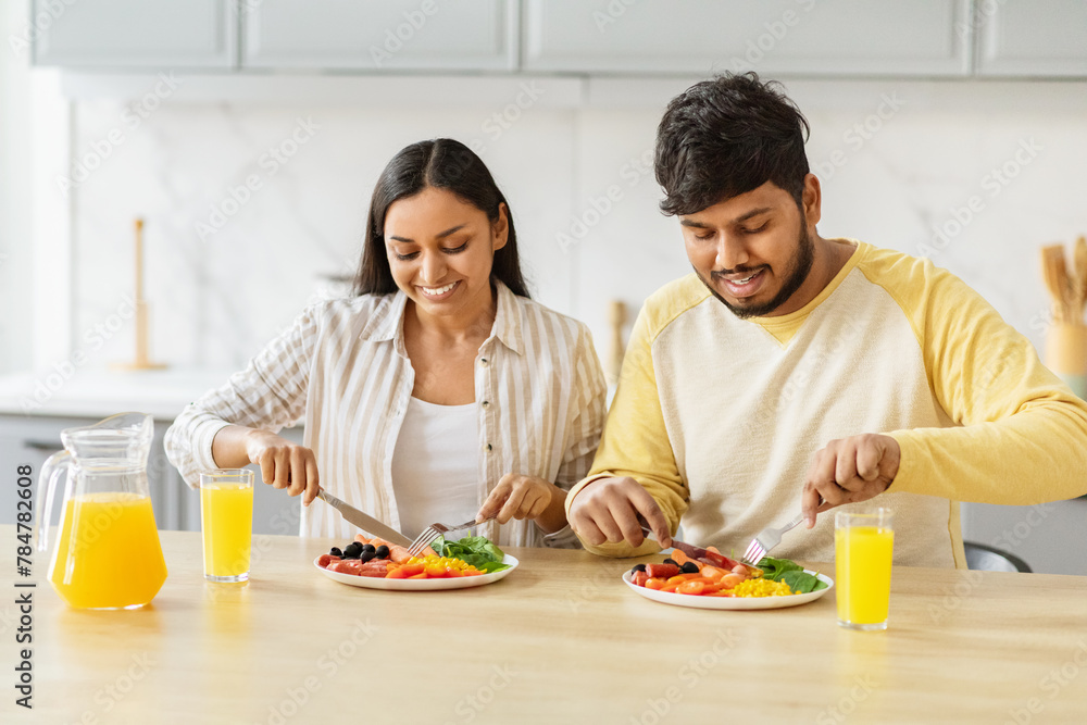 Couple eating healthy meal together happily at kicthen Couple eating healthy meal together happily at kicthen