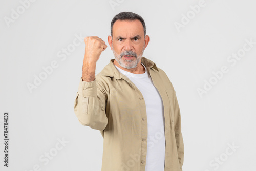 Determined senior man making a fist on white background photo