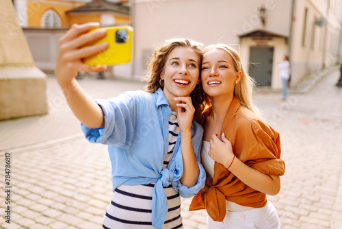 A tourist's woman walks the streets and takes selfie using smartphone camera. Lifestyle, travel, tourism, active life.