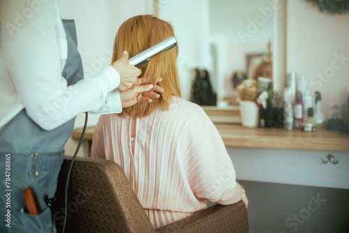 Seen from behind woman hairdresser in modern beauty salon