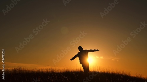 Child boy play Fly like an airplane, in park opposite sky sunset. Boy aviator dreaming raised his hands to wings of plane on field in rays of sun. Child wants to become an astronaut pilot. Superhero photo